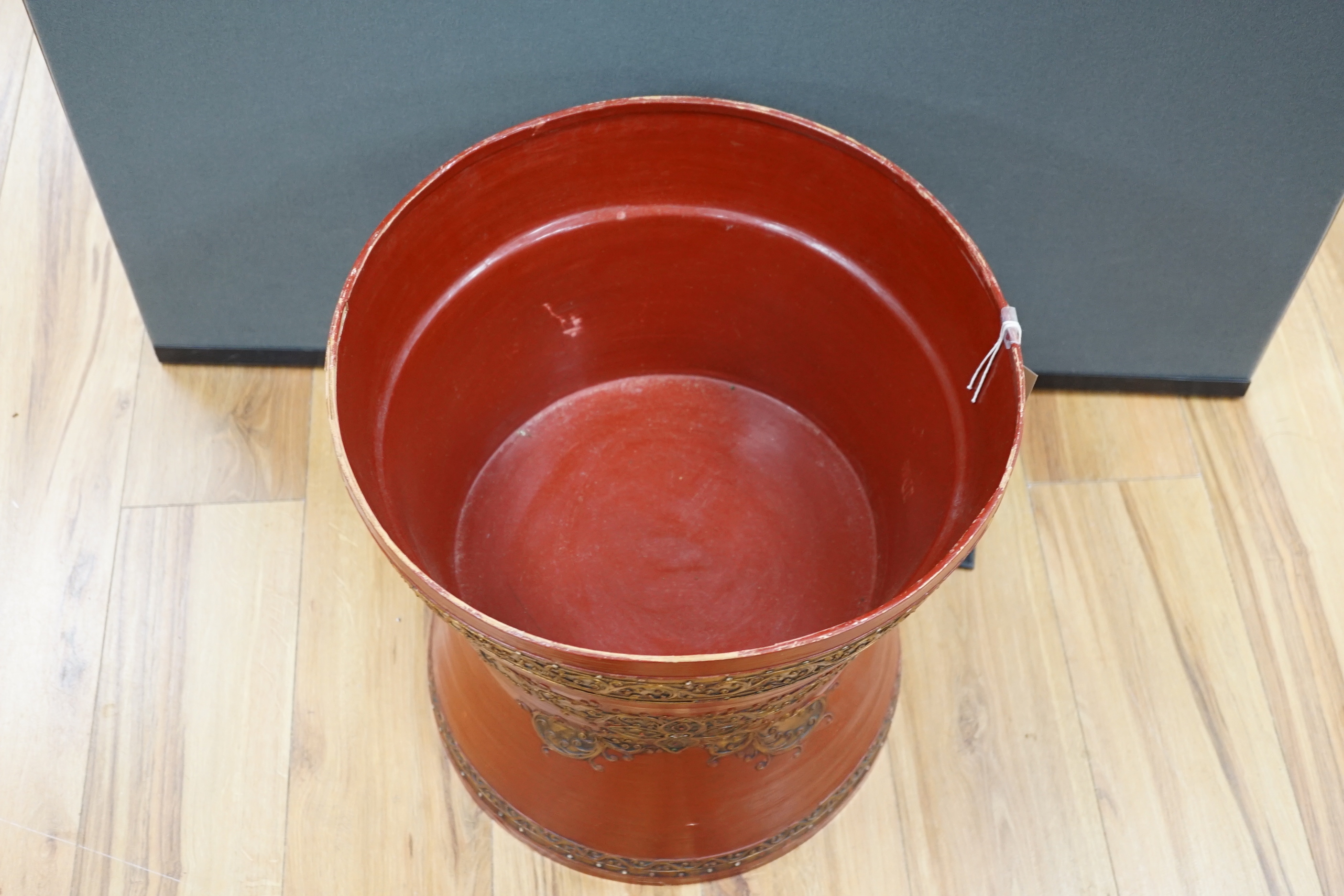 A South East Asian composition red lacquered table inset mirrored sequins, 44cm high x 51cm in diameter